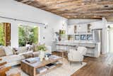 Inside, crisp white walls pop against the wooden ceilings and floors. A large central island with a breakfast bar separates the kitchen from the living area.