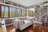 A cozy library awaits on the upper level, complete with floor-to-ceiling custom shelving.