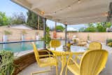 The fenced-in backyard has a covered dining area and a sparkling pool.