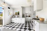 Dressed in black and white checkered tiles, the airy kitchen offers direct outdoor access.