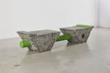 In SLAB, a steel pole painted green pierces two chunks of marina granite to create a bench.
