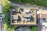 An aerial view shows the home’s spacious rooftop deck, complete with a grilling station, multiple seating areas, and outdoor heaters.