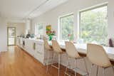 Picture windows dot the open kitchen, ushering in plenty of natural light. A glass door leads to the nearby garden.