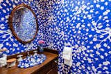 Bright blue wallpaper provides an unexpected pop of color in lower-level bathroom.