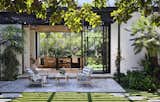 Outdoor furniture from Frontgate sits on the dining terrace off the kitchen. Immense sliders enable gatherings to move indoors and out.  Photo 6 of 16 in A Secret Garden Springs to Life Around a Glassy Olson Kundig Home