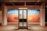 Asteroid City costumes, props, and set pieces—such as the telephone booth and ‘Arid Plains Meteorite’ billboard—are on display as part of a London exhibit at 180 Studios through July 8.