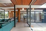 An open air atrium entrance leads to the home's main living areas, where original globe light fixtures dot the tongue-and-groove ceilings.