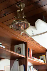 In the entryway, a reclaimed light from Portland Architectural Salvage in Maine shares space with a surfboard suspended from the original shiplap ceiling.