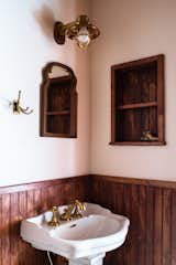 “All of the bathrooms needed a lot of work,” says William, who, with Beth Anne, selected a Barclay Stanford 550 pedestal sink to replace a short, built-in vanity in the shared bathroom. A vintage mirror complements a caged sconce from Portland Architectural Salvage.  Photo 2 of 17 in 17 Modern Bathroom Wall Ideas from She Grew Up in a Spot-On Replica of a Maryland Lighthouse. Now, She’s Giving It Her Own Shine