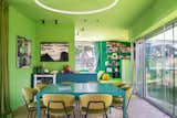 Dining room with vibrant green walls, and turquoise table in Turin, Italy