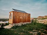 Wooden tiny home with masonry base on hilltop in Sintra, Portugal, at sunset