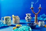 Grottaglie Italy colorful speckled and splattered ceramic pitcher, artist's spoon crock, tiny bowl, rock vase, cereal bowl, two-armed candelabra, and dimple cup made by March, Helen Livi, Owo, and Utility object photographed with a blue backdrop