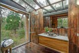 The en suite bathroom in the Mountain View cabin has a full-ceiling skylight and a glass wall.