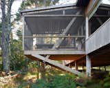 The home has a small footprint, but elements like a screened, cantilevered porch emphasize a connection with the woods.