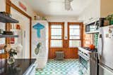 The kitchen features original wood paneling and bright green tile.