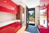 Bright-red cabinetry shines in the mudroom/laundry area.