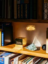 Medium-stained rimu wood shelves with books and small geometric objects in additional dwelling unit in Miramar, Wellington, New Zealand.