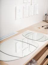 Glass tabletops laid out on wood workbench in Clara Jorisch’s Montreal workshop.