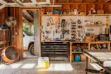Mulhy furniture studio’s workshop in Fredericksburg, Texas, with tools hung on wall above workbenches and tool box.