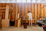 Member of Muhly furniture studio stands at workbench in workshop in Fredericksburg, Texas