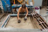 Maikia Palazuelos, founder of Panorammma studio, sifts through vat of sand in Mexico City workshop.