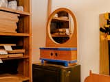 Round wood-framed mirror stands on box in Los Angeles workshop of Adi Goodrich, founder of Sing Thing.