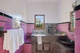 The primary bathroom features a mix of original pink tile and custom contemporary finishes.