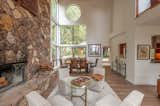 A stone fireplace anchors the living/dining area, which is wrapped in glazing.
