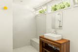 The sun-filled bathroom awaiting in the primary suite features a spacious tiled shower.