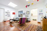 Patterned rugs and furniture add vibrant bursts of color in the all-white study upstairs.