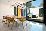 The dining area is adjacent to the internal courtyard, and large glazed walls frame the newly colored vertical slats in the hallway. With a simple application of color, this feature has been transformed into architectural artwork.&nbsp;