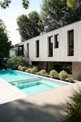 A linear pool runs alongside the home, evoking the same strict geometric language of the architecture. The landscaped garden softens these lines and mirrors the forested landscape.