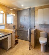 Mikiten remodeled the top floor bathroom without moving walls, creating a roll-in shower, wheelchair-friendly sink, and rearranging the fixtures. Fran liked having the window, so a mirror was wrapped around it.