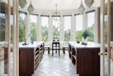 Tall windows infuse the kitchen with ample natural light.