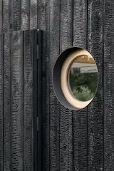 Byro Architects used yakisugi cladding for the facade to make the structure match other huts in the area, which have black or brown exteriors.