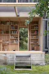 Byro used the foundation from the hut that stood before to build the new pavilion. Floor-to-ceiling shelves provide a place to store books.  Photo 2 of 21 in Tiny Homes by Stephen Littell from Budget Breakdown: A Garden Shed for $43K? It’s Not Meant for Storing Tools