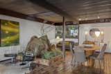 Exposed beams stretch across all the living spaces, including the dining area where a large rock projects from the floor, paying homage to the rock outcrop the home is built around.  Photo 6 of 11 in Dave Brubeck’s Cantilevered Midcentury Home Lists to the Tune of $3M