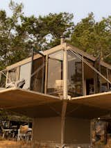 Balconies suspended from boxy steel-framed home  in Camp Everhappy on San Juan Islands, Washington, restored by Jason F. McLennan.