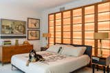 Bedroom with orang fabric paneled wood screen in midcentury internationalist home in Wyomissing, Pennsylvania by Muhlenberg Brothers and renovated by Kevin Yoder and Louise Cohen.