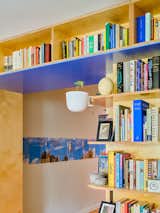 Millwork bookcase shelves library with blue laminate surfaces in Brooklyn apartment renovated by Spot Lab.