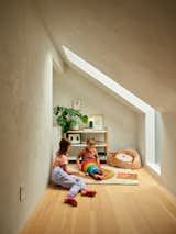 The children’s reading area off their bedroom, affectionately called the book nook, has an eave skylight that Andrew made from a reclaimed piece of safety glass. The aperture opposite the skylight looks down into the living area.