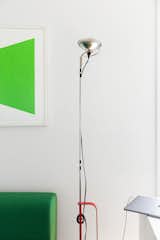 A silver-and-red Castiglioni lamp illuminates the primary bedroom.