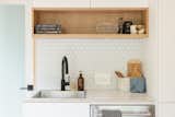 Kitchen of aux box model 240 prefab prefabricated home with white cabinetry, black faucet, and laminated wood counter.