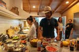 Friends cook together in the kitchen. The overhead beams were part of the renovation.