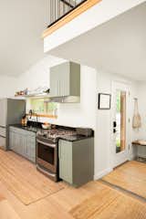In the main living space, green - gray cabinets from Lowes,  Photo 1 of 6 in Kitchen by Karen Henricks from Budget Breakdown: Their Maine Property Only Had One Bathroom, So They Built a Guesthouse for $208K
