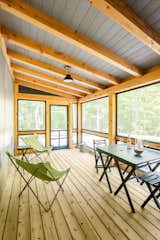 A timber-framed screened porch gives guests a place to sit outside without being swarmed by mosquitos.
