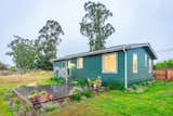 Villa prefab ADU small home with fiber cement lap siding, asphalt gable roof, and large wood deck in California backyard.