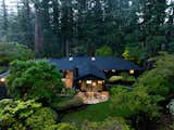 As part of the renovation, the home now features a sleek black exterior, helping it blend into the surrounding natural setting.  Photo 2 of 10 in In Portland, a Woodsy Midcentury Seeks $1.6M After a Dramatic Revamp