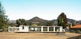 White metal clad Connect Homes prefab prefabricated Designer Series home house sits on construction site in California after being lowered by crane.