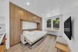 Murphy bed folds out of white oak veneer cabinetry in Single Family Home prefab ADU by Bequall.